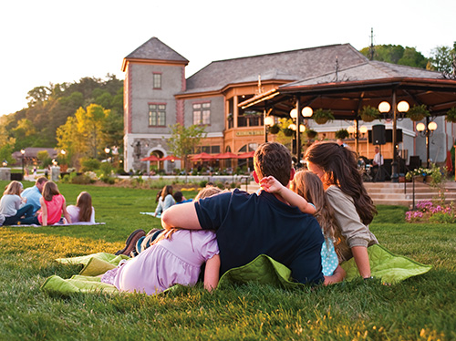 A family enjoys live music at dusk at Antler Hill Village at the Biltmore Estate